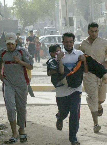 Un iraquí corre para llevar a un niño herido al hospital en Bagdad.