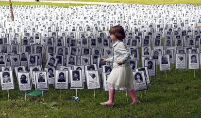Una niña camina junto a los rostros de las víctimas de Prijedor durante la guerra de Bosnia, en un parque en Sarajevo (Bosnia), el 31 de mayo de 2019. Las imágenes muestran 3.176 bosnios y croatas, incluidos 102 niños, naturales del pueblo de Prijedor, que fueron matados por serbobosnios durante la guerra de Bosnia, entre 1992 y 1995. El 31 de mayo es el día recordado como el de los brazaletes blancos, distintivo que debían llevar bosnios y croatas, para distinguirse de los serbobosnios. 