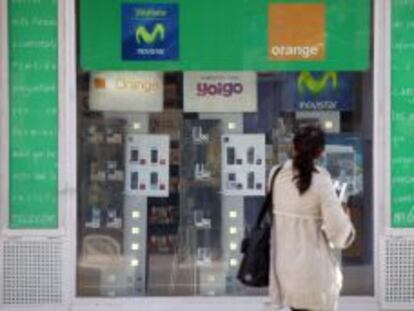 Mujer frente a una tienda de telefonía móvil.