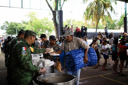 Soldiers distribute food at a shelter in Tulum on July 5.