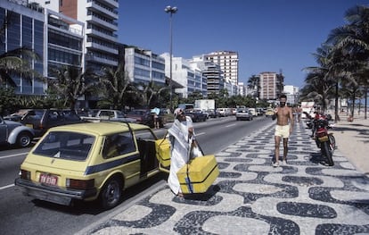 Outro vendedor de rua descarrega seu equipamento de um carro no calçadão da Praia do Leblon, no Rio de Janeiro.