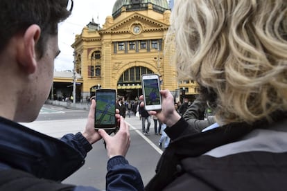 Dos estudiantes prueban el nuevo juego 'Pokémon Go' en Melbourne, Victoria, Australia.