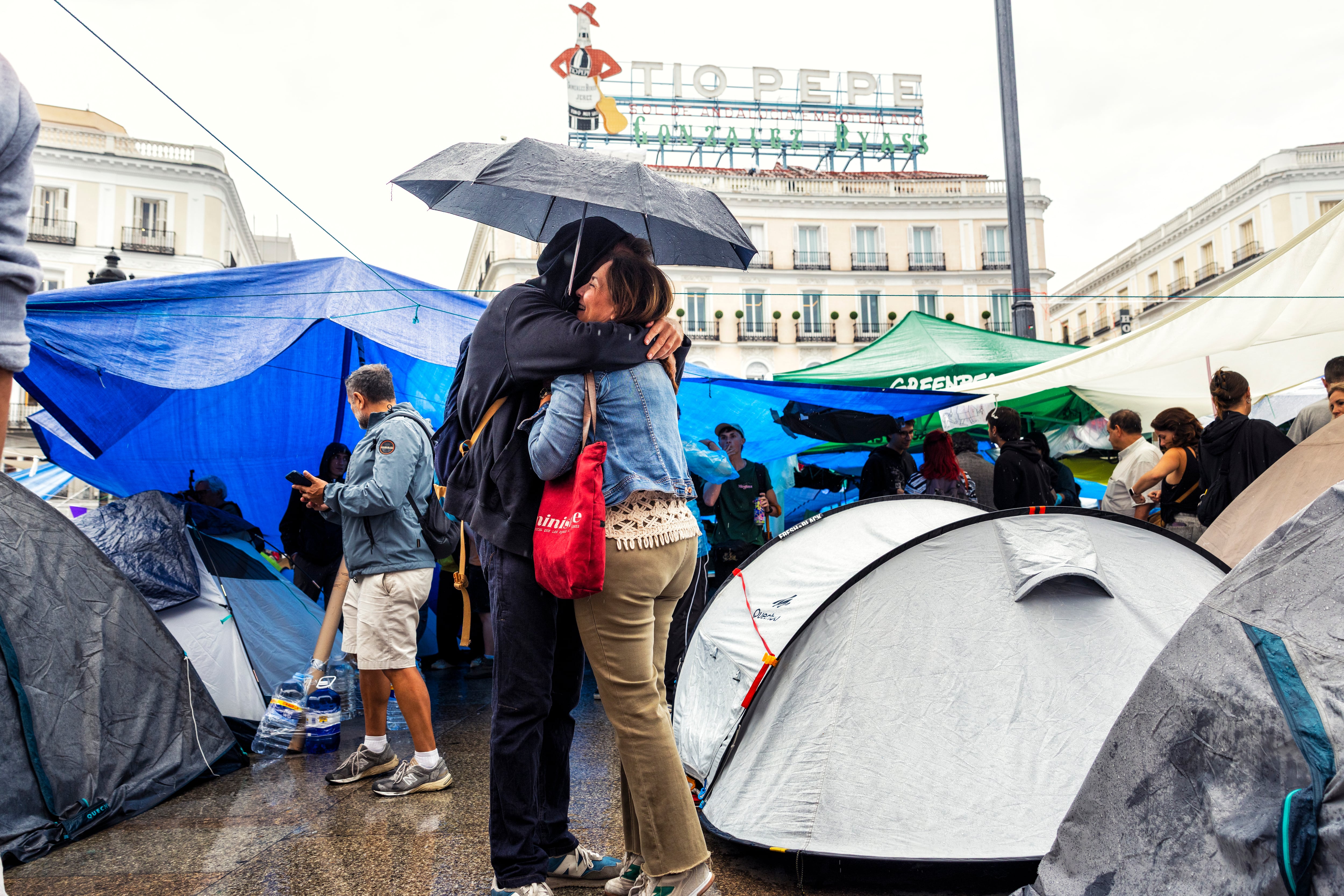 Un abrazo en el campamento de la Puerta de Sol, este lunes.