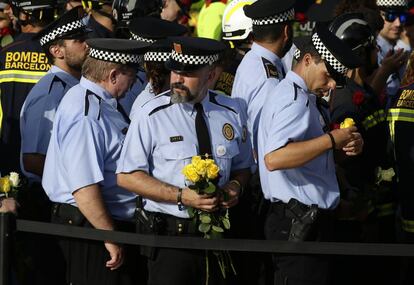 Un grupos de agentes de policía con rosas rojas y amarillas, en la manifestación en el paseo de Gràcia.