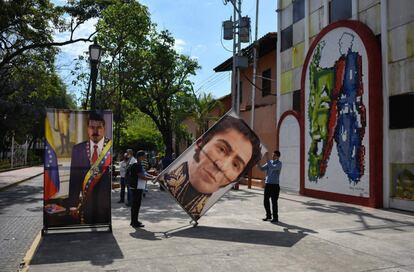 Dos hombres sujetan carteles con las imágenes del presidente venezolano Nicolás Maduro y Simón Bolívar, en Barinas (Venezuela).