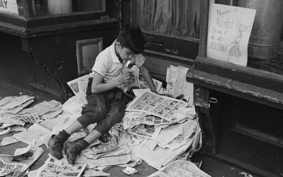 Ni&ntilde;o leyendo tebeos en una calle de Nueva York en 1945.