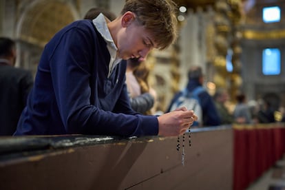 Un joven reza en la basílica de San Pedro donde se encuentra instalada al capilla ardiente de Francisco, este viernes. 