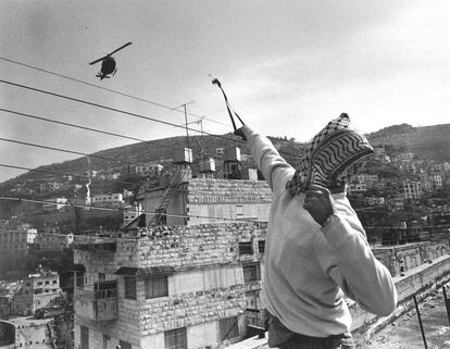 A Palestinian teenager fires a slingshot at an Israeli army helicopter in Nablus during the First Intifada in 1988.