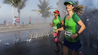 Dos corredoras cruzan el paseo marítimo de Ipanema durante el medio maratón de Río de Janeiro.