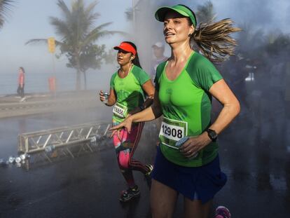 Dos corredoras cruzan el paseo marítimo de Ipanema durante el medio maratón de Río de Janeiro.