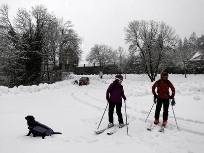 Dos esquiadores y un perro disfrutan de la nieve en el parking de Roncesvalles (Navarra), el pasado diciembre.