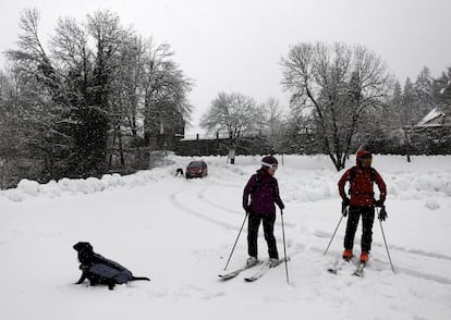 Dos esquiadores y un perro disfrutan de la nieve en el parking de Roncesvalles (Navarra), el pasado diciembre.