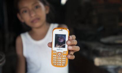 Una niña muestra la foto de su sobrino, que nació con microcefalia.