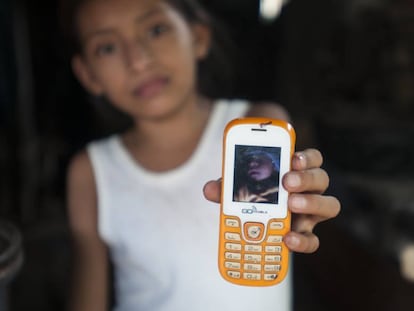 Una niña muestra la foto de su sobrino, que nació con microcefalia.