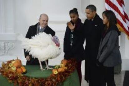 El presidente de Estados Unidos, Barack Obama (2d) y sus hijas Malia (d) y Sasha (3d), junto con el presidente de la Federaci&oacute;n Nacional del Pavo, John Burkel (i) durante el perd&oacute;n otorgado por el presidente en un acto celebrado en la Casa Blanca, Washington, Estados Unidos hoy 27 de noviembre de 2013. El pavo, llamado &#039;Popcorn&#039; (Palomita de ma&iacute;s) mide dos pies y pesa m&aacute;s de 17 kilos.