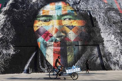 Un hombre en bicicleta pasa delante de un mural creado por Eduardo Kobra para decorar un edificio en el Distrito del Puerto, un área renovada antes de los Juegos Olímpicos de Río 2016.
