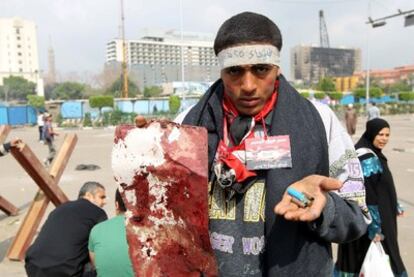 Un participante en las protestas de ayer muestra balas gastadas y una hoja manchada de sangre en la plaza Tahrir.