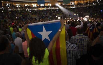 Una mujer levanta una Estelada en el interior del Tarraco Arena.  