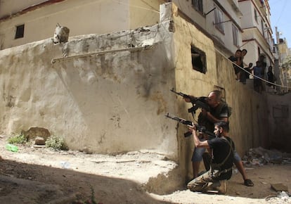 Dos milicianos suníes disparan contra partidarios de El Asad, durante los combates registrados en la ciudad libanesa de Trípoli.