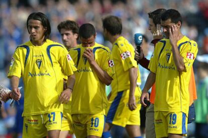 Los jugadores del Cádiz se retiran cabizbajos del terreno de juego.