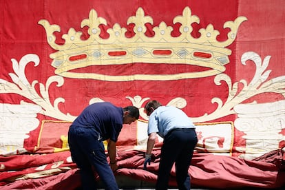 Trabajadores colocan un escudo real en el exterior del Congreso.