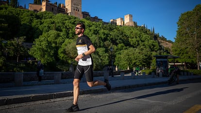 Un hombre corre por el Paseo de los Tristes de Granada, con la Alhambra de fondo. FERMÍN RODRÍGUEZ