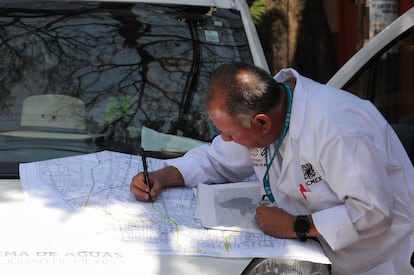 Un trabajador de Sacmex revisa un plano con las distintas tuberías del área que presentó agua contaminada, el 10 de abril de 2024.