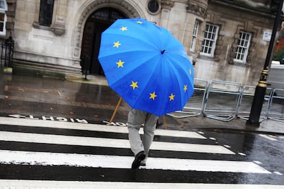 Un hombre pasea con un paraguas con la bandera comunitaria, en Londres en 2019.