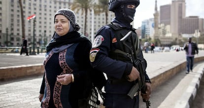 Uma mulher passa ao lado de um soldado, próximo à praça Tahrir.