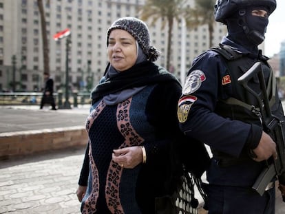 Uma mulher passa ao lado de um soldado, próximo à praça Tahrir.