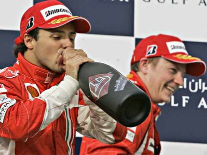 Felipe Massa, el ganador, bebe en el podio junto a Kimi Raikkonen, su compañero en Ferrari, segundo.