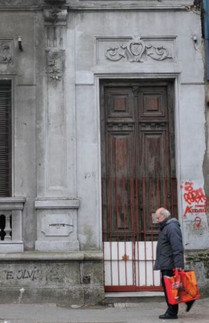 Um homem passa na frente de um edifício abandonado em Montevidéu.
