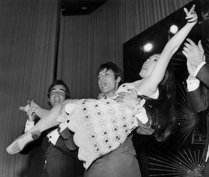 El británico Cliff Richard lleva en brazos a a Massiel tras alzarse ganadora en Eurovisión en 1968, mientras Ramón Arcusa, uno de los autores de la canción, lo celebra.