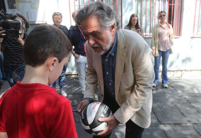 El candidato del PSOE al Ayuntamiento de Madrid, Pepu Hernández, vota en el colegio público Padre Coloma, en Madrid. En la imagen, firma el balón de un niño a la salida del centro.