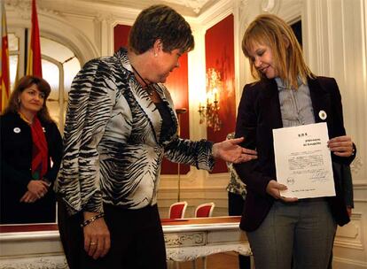 Leire Pajín (derecha) muestra su acta de senadora.