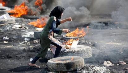 Una manifestante, entre neumáticos quemados, este jueves en Bagdad.