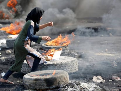 Una manifestante, entre neumáticos quemados, este jueves en Bagdad.