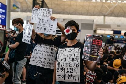 Manifestantes muestran pancartas mientras ocupan la sala de llegadas del aeropuerto de Hong Kong, el 12 de agosto de 2019.