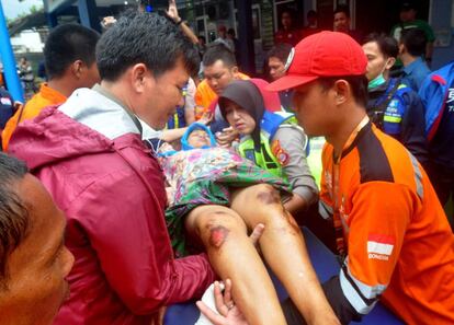 As equipes de resgate transportam uma mulher ferida pelo tsunami na Indonésia.