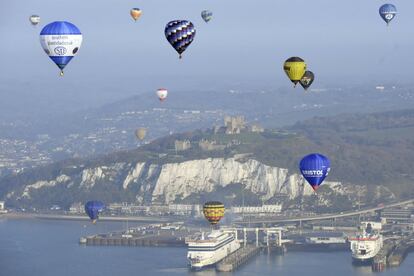 Algunos de los 100 globos que participan en un intento de Récord Mundial de globo con el objetivo de cruzar el Canal de La Mancha sobrevuelan el puerto de Dover, en la ciudad de Kent, Inglaterra.