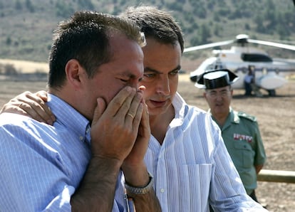 El alcalde de Ablanque (Guadalajara), Jose Miguel del Castillo (i), llora en presencia del presidente del Gobierno, José Luis Rodríguez Zapatero (d), durante la visita de este último a la zona afectada por las llamas.