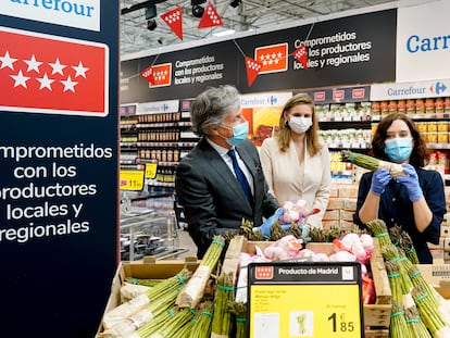 La presidenta de la Comunidad de Madrid, Isabel Díaz Ayuso, sostiene un manojo de espárragos del Carrefour de Alcobendas.