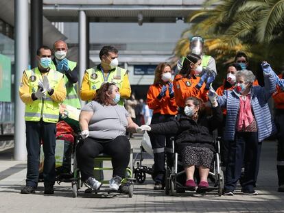 Gloria (l) leaves the Ifema field hospital in a wheelchair on Friday.