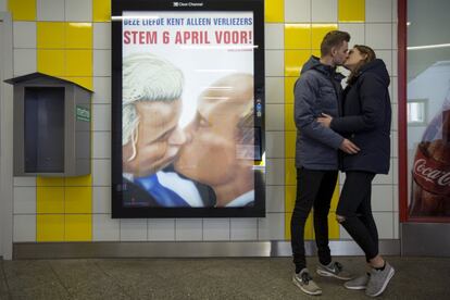 Um casal se beija junto a um cartaz que representa ao político holandês Geert Wilders e ao presidente russo, Vladimir Putin, no metro de Amsterdã (Holanda), em 3 de abril de 2016.