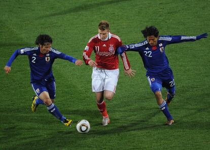 El danés Nicklas Bendtner es rodeado por los jugadores japoneses Yuki Abe y Yuji Nakazawa.