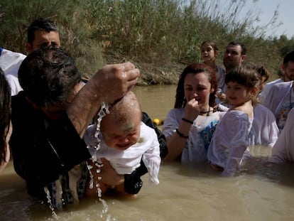 Un sacerdote serbo-ortodoxo bautiza a un beb&eacute; en el Jord&aacute;n el abril. 
