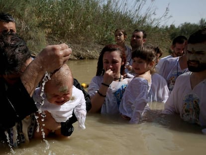 Un sacerdote serbo-ortodoxo bautiza a un beb&eacute; en el Jord&aacute;n el abril. 