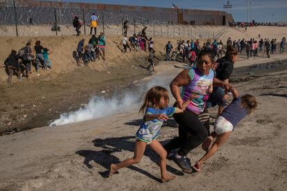 Maria Meza, hondureña de 40 años, intenta junto con sus dos hijas evitar los gases lacrimógenos lanzados contra una caravana de migrantes en la frontera con Estados Unidos en Tijuana (México), en noviembre de 2018. 