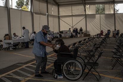 Una pareja de adultos mayores se acompaña para vacunarse.