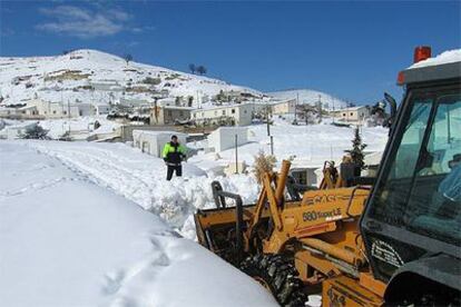 Una máquina excavadora retira la nieve acumulada en las calles de Baza (Granada).